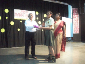 Mr. TK Mathew is giving an award to a girl child 